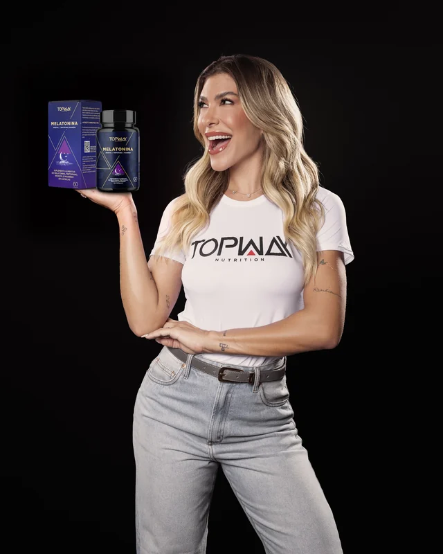Lore Improta, com a camiseta da Topway, apresentando a caixa e o frasco da Melatonina Topway